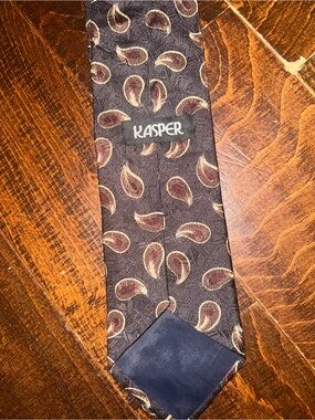 Kasper branded neck tie features a black and burgundy paisley pattern